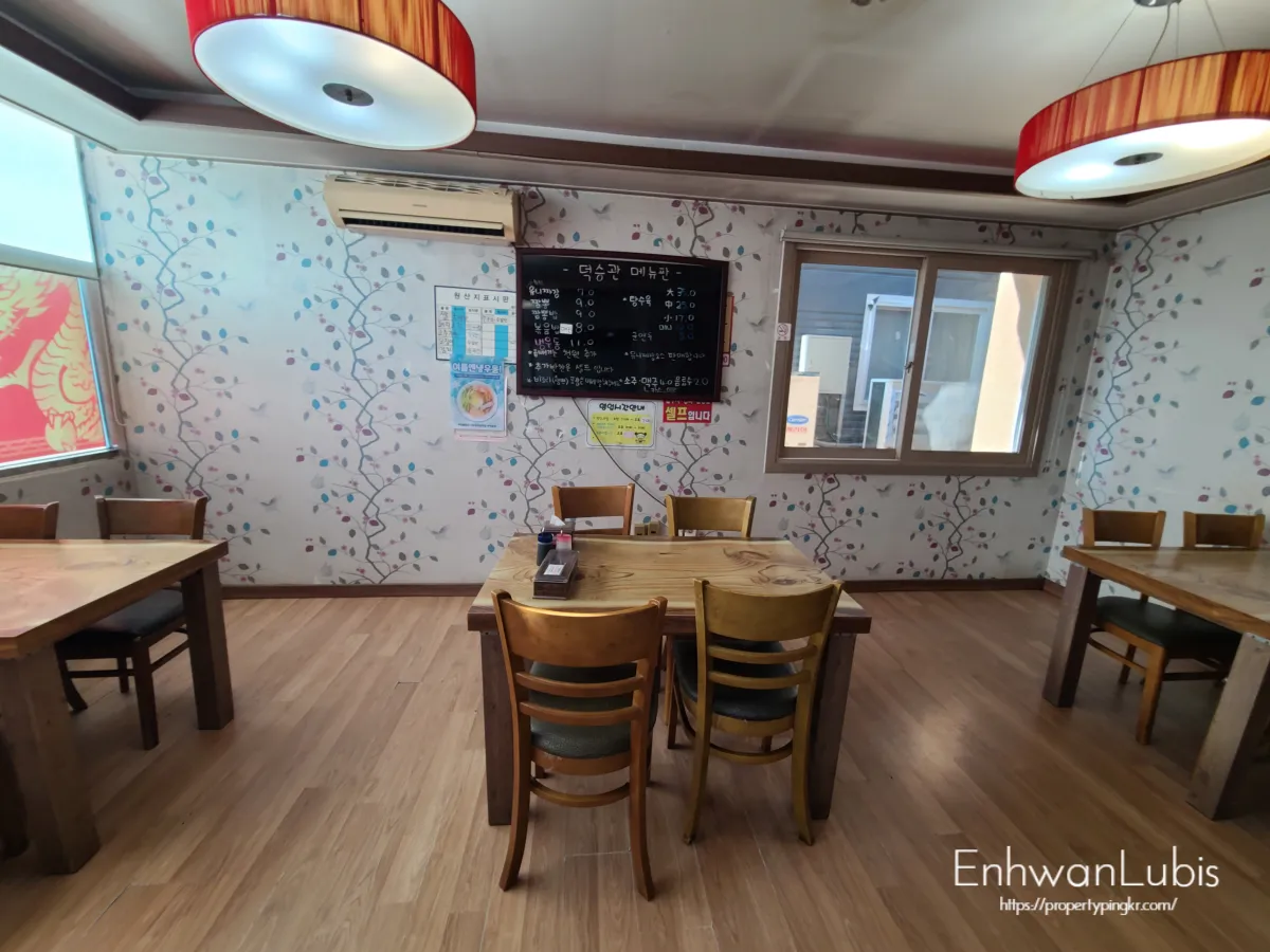 파란색과분홍색-넝쿨이그려진-벽지-빨간색포인트의-동그란모양의-등-3개의나무테이블이-놓여있는