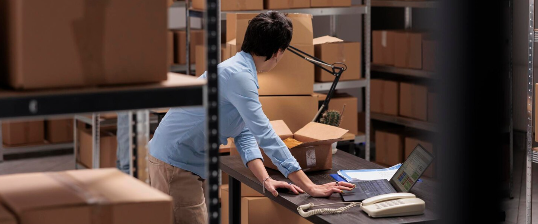 창고 작업자가 재고 관리 프로그램에 데이터를 입력하고 있는 모습