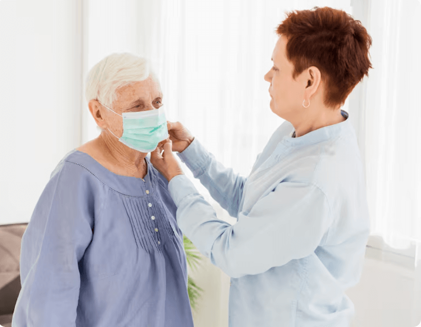 할머니의 마스크를 씌어주고 있는 가족