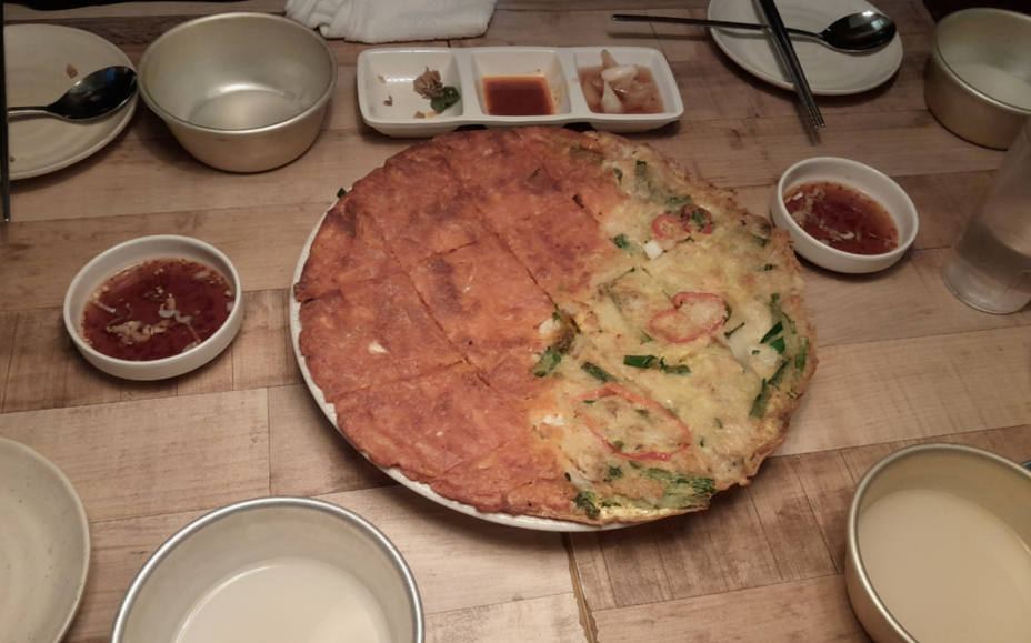 그릇위에 태극 모양으로 해물파전과 김치전이 구워져 있다. 