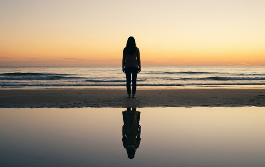 석양이지는 해변에서 자신의 내면을 들여다보며 현재와 과거의 연결을 느끼는 사람의 실루엣