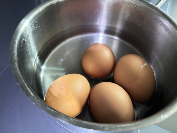 물이 담긴 냄비에 삶은 달걀이 있는 사진