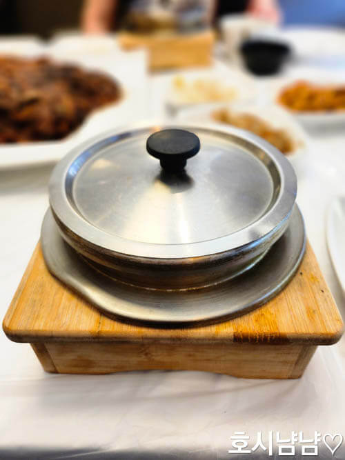 코다리덕장 돌솥밥은 손잡이가 달린 나무 받침에 따뜻하게 나와요.