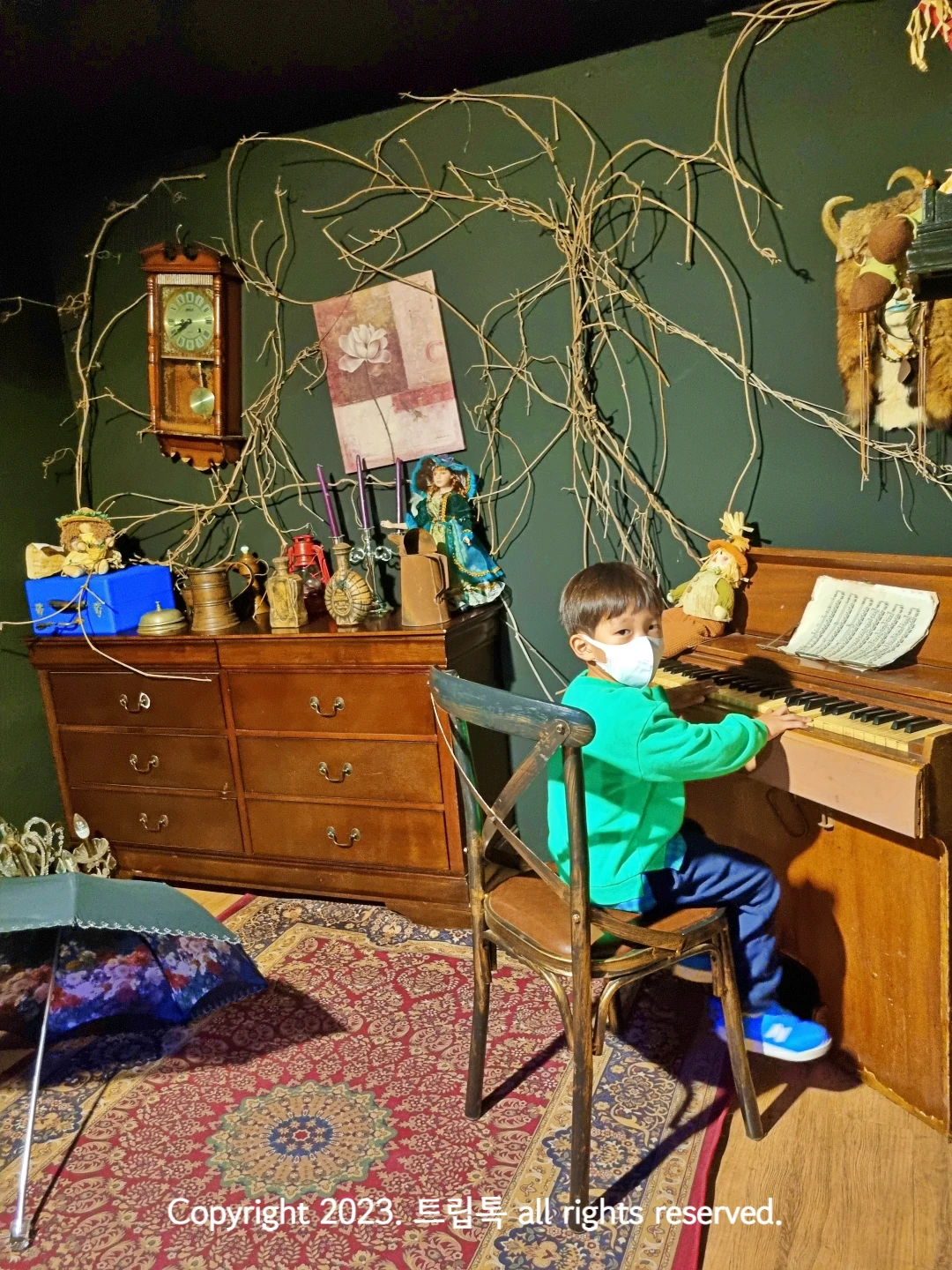 원목 가구와 피아노를 치는 아이