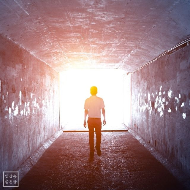 터널 끝 밝은 빛을 향해 걷는 남성 실루엣 – 인생 역경을 극복하는 희망의 이미지