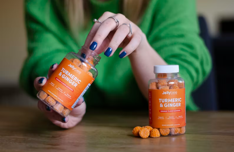 비타민 보충제를 손에 들고 꺼내는 여성의 모습. 건강 관리를 위한 영양제 섭취 장면