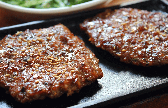 네모난 판에 2개의 네모난 떡갈비가 나란히 놓여있다.