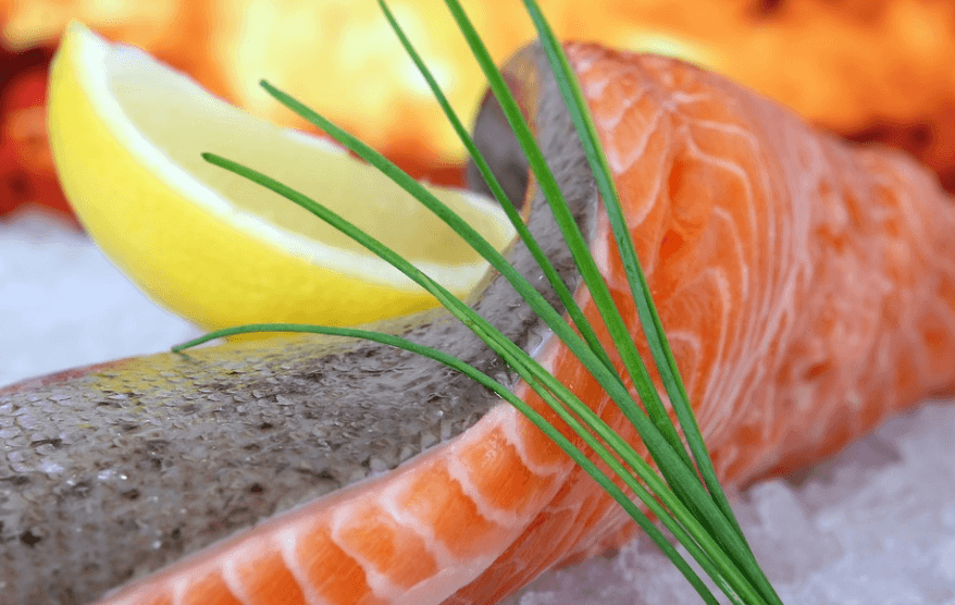 레몬과 함께 연어 회가 놓여 있다