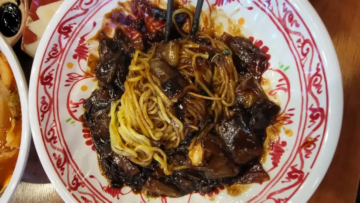 보배반점 -
흰 그릇 안 빨간 줄무늬 그릇에 노란색 면과 검은 자장이 섞인 자장면