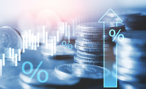 알트태그-동전이 쌓인 위로 다양한 경제 지표가 보입니다.