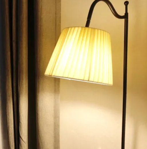 스탠드가 켜져있는 상태로 커텐 옆에 놓여져 있다.