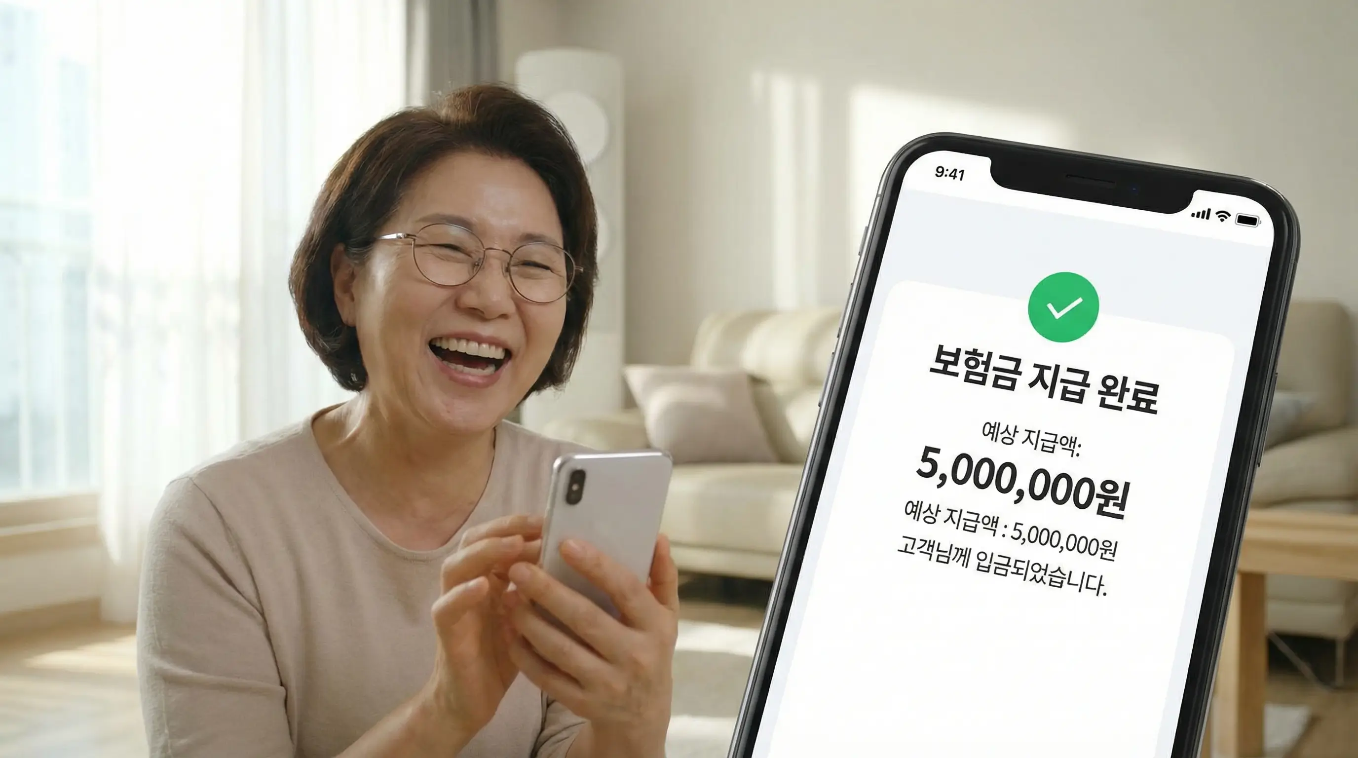 보험금 지급 완료 알림이 뜬 스마트폰 화면을 보며 기뻐하는 사람의 밝은 표정