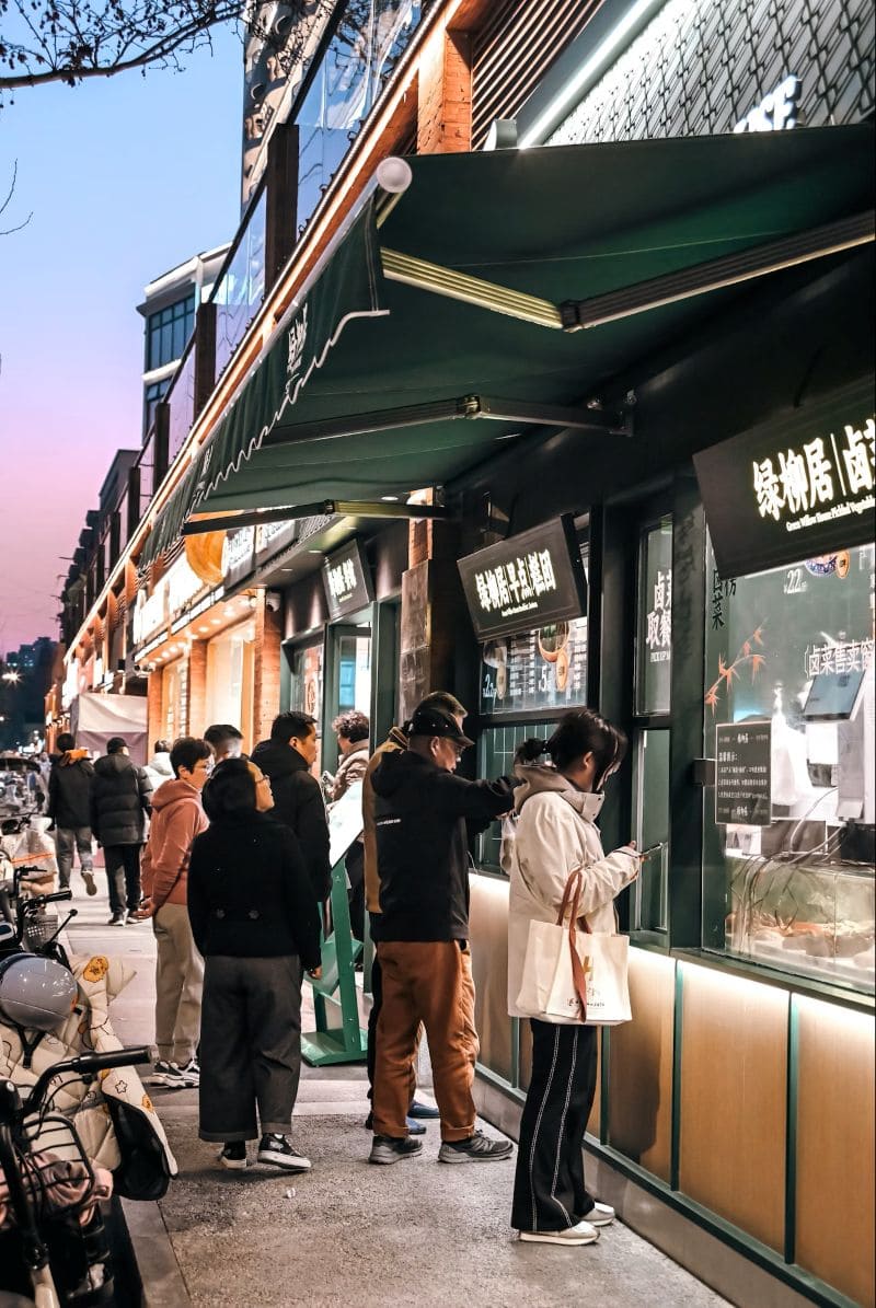 난징 번화가의 테이크아웃 음식점 앞, 사람들이 줄을 서서 음식을 주문하고 대기하고 있는 저녁 시간 거리 풍경