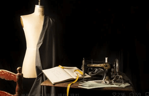 어두운 검은색 톤 사진이며 옛날 재봉틀과 마네킹이 있는 사진입니다.