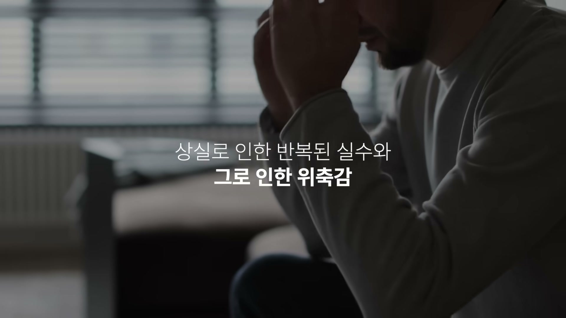 어두운 방 안에서 누군가 두 손으로 머리를 감싸쥐고 앉아 있는 모습 위에 위축감을 설명하는 자막