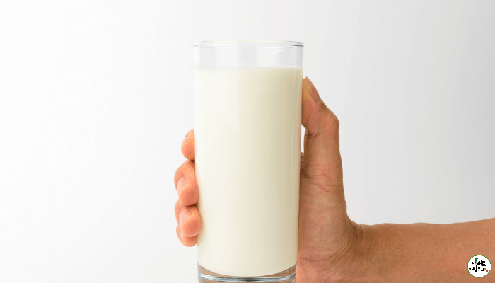 손에 쥔 유리컵에 산양유 단백질이 담겨있다