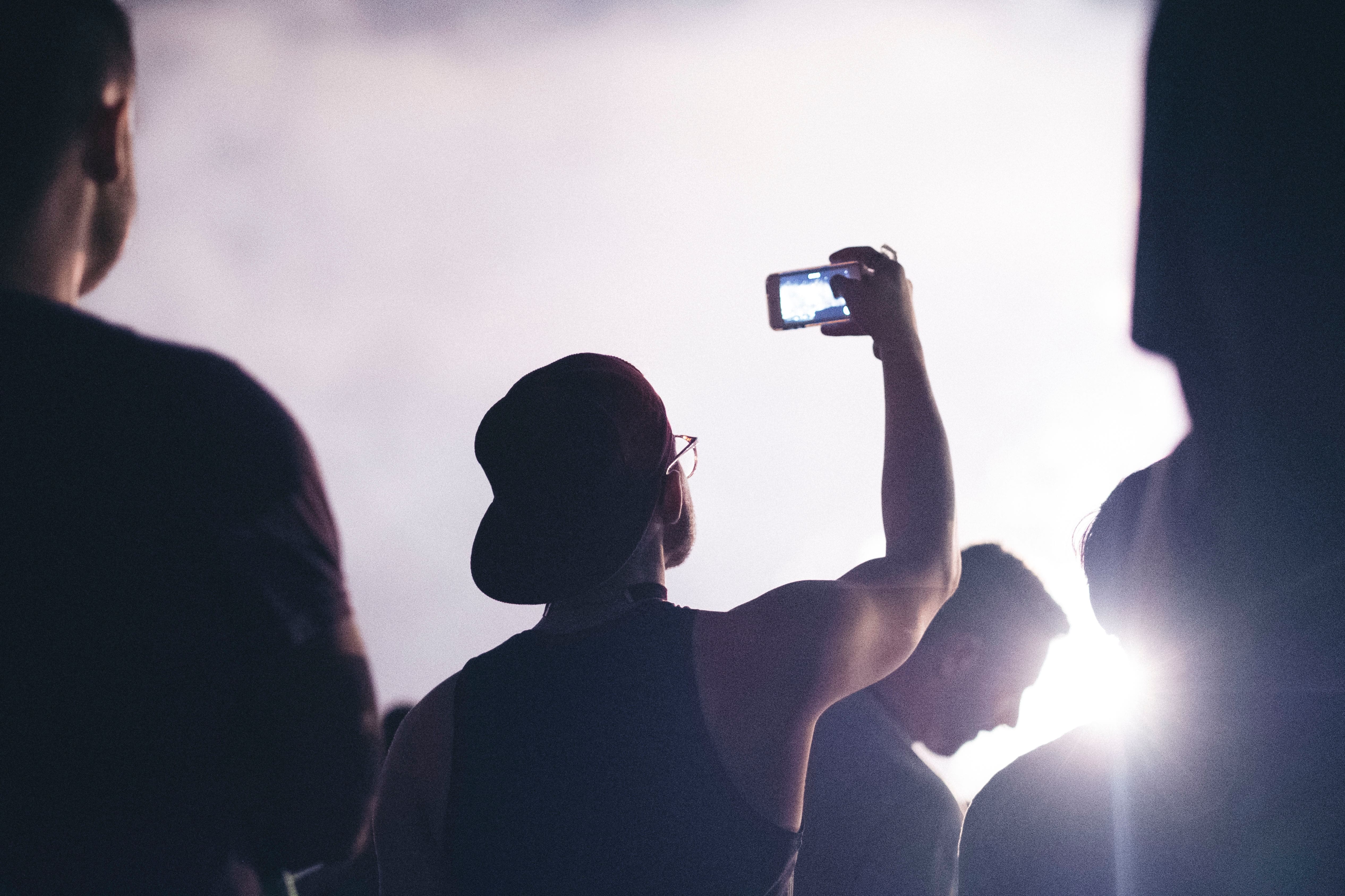 A man filming himself doing something with his smartphone