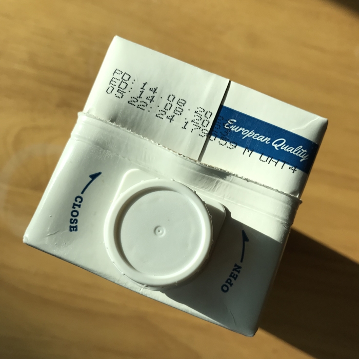 갓밀크 멸균 우유 상단 뚜껑 부분. 유통기한과 제조일자가 인쇄되어 있으며, 'European Quality' 인증 문구와 OPEN&middot;CLOSE 방향 표시가 함께 보인다.