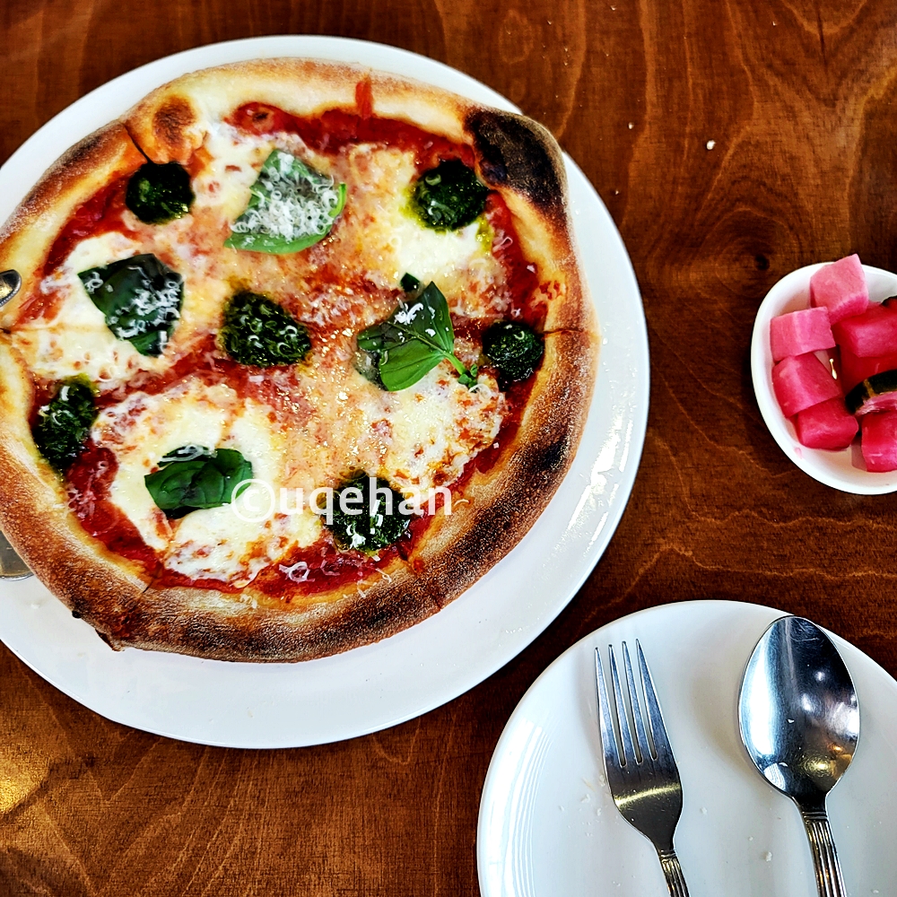 피자한접시와 피클 그리고 접시위에 포크와 숟가락이 올려져 있다.