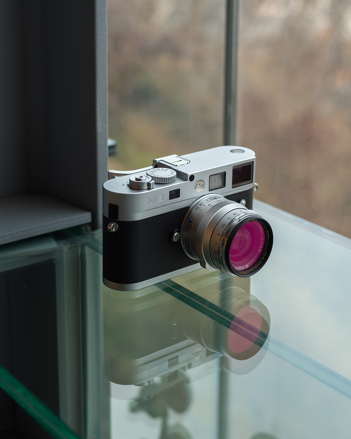 유리 테이블 위에 라이카 M8이 놓여있다. 한 눈에 보아도 황동의 묵직함이 느껴질 정도로 단단한 모습이다.