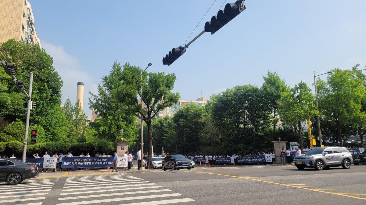 현대건설 직원들이 압구정2구역 앞에 현수막을 들고 도열해 자사를 홍보하고 있다.