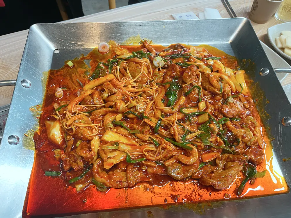 철판에 익어가고 있는 빨간 양념의 오리주물럭