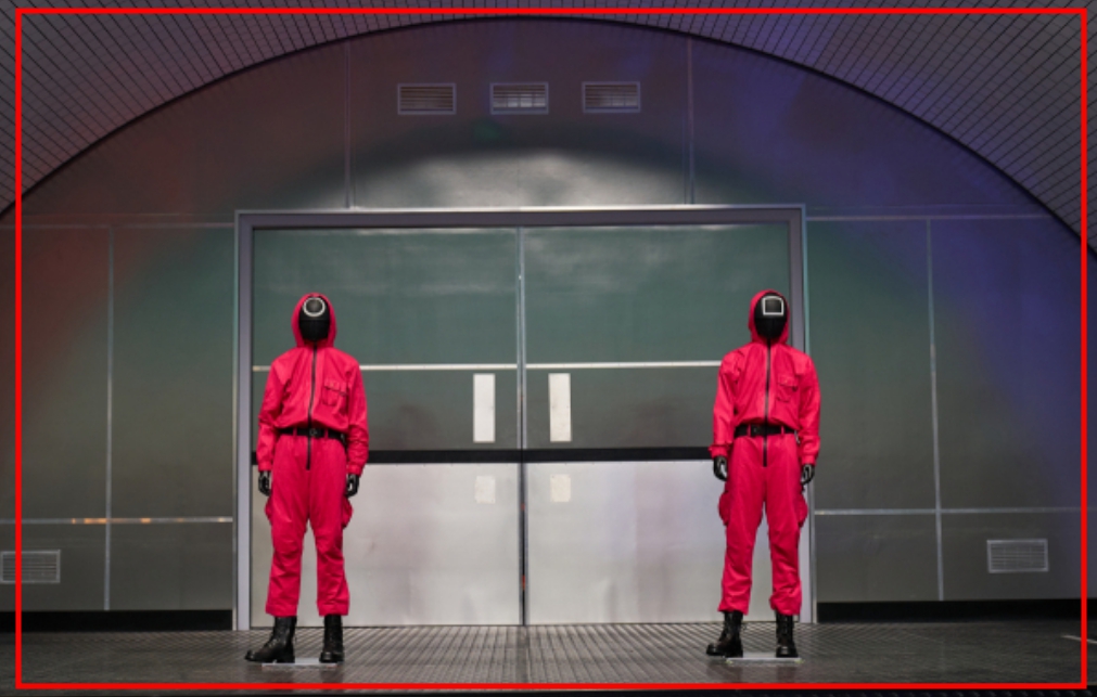 문 앞에 빨간색 옷입은 두사람이 서있는 모습