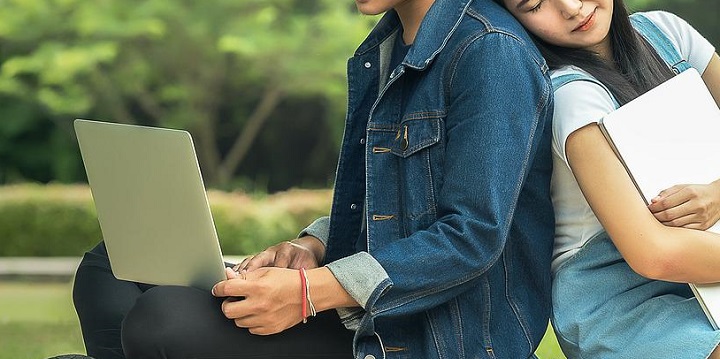 노트북보면서 앉아있는 청년 남녀