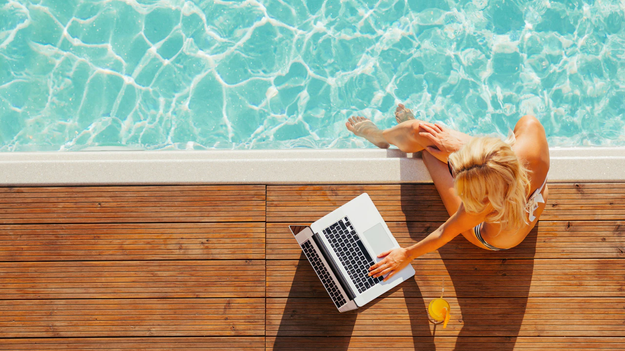 수영장 옆에 앉아 노트북 보는 여성