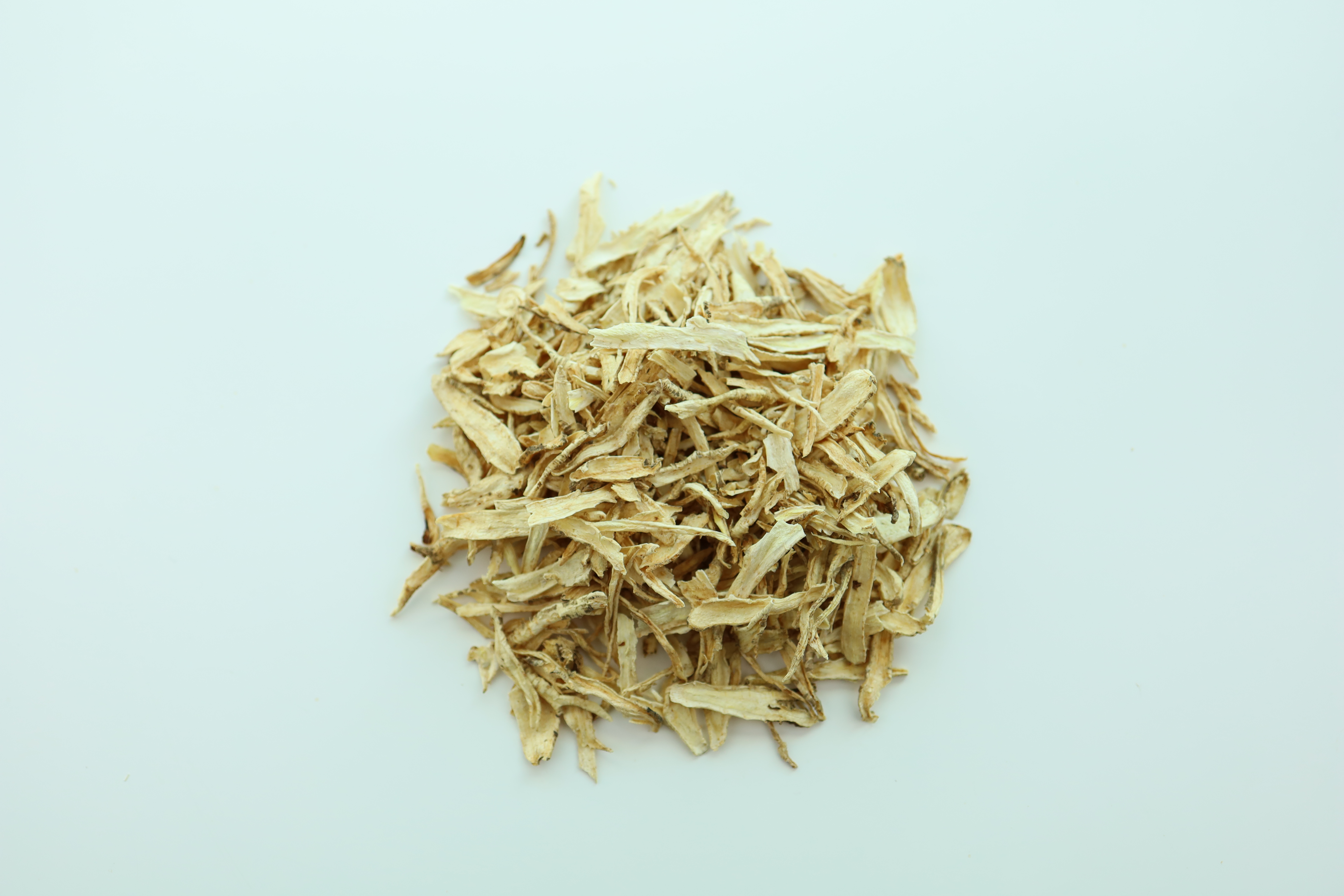 야생에서 채취를 한 도라지의 뿌리인 길경을 잘 세척하고 건조한 후에 편으로 잘게 썰어서 하얀 바닥 위에 수북하게 쌓아놓고 찍은 사진