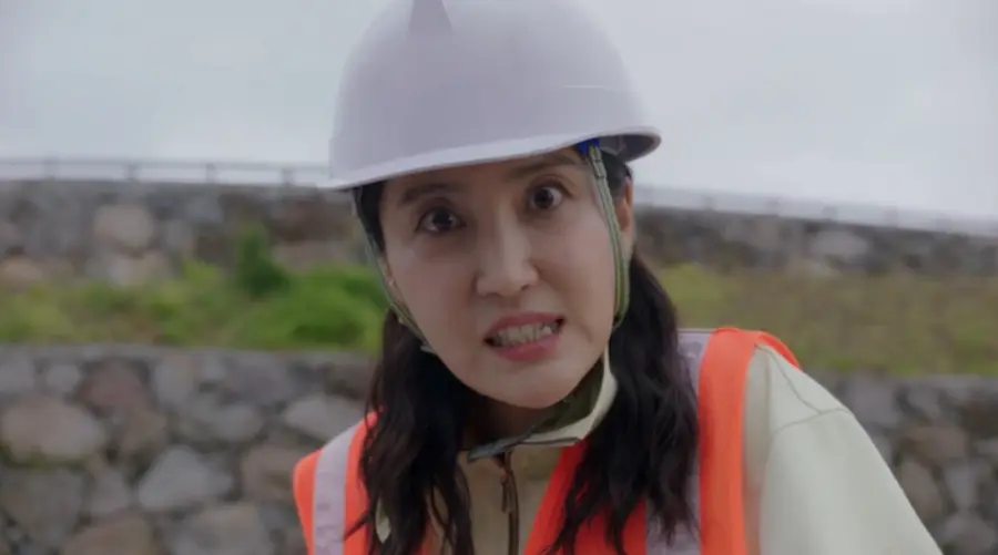 웰컴투삼달리- 머리에 공사용 모자를 쓰고 주황색 공사용 조끼를 입고 화를 내는 조삼달 언니