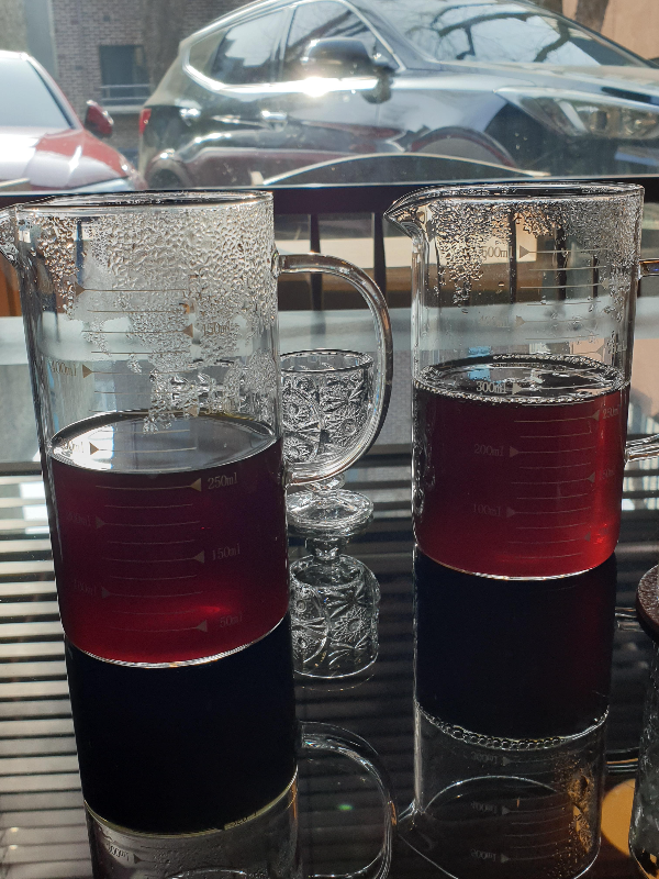 테이블 위에 커피가 든 비커 2개와 작은 잔 하나가 보인다.