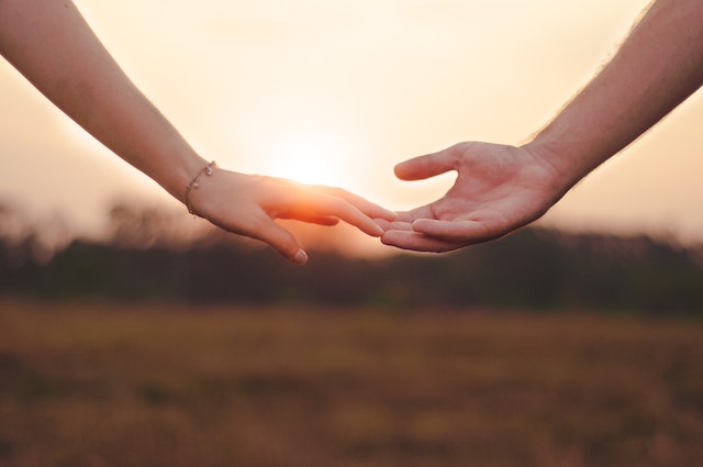 해질 무렵 두 사람의 손이 서로 맞닿아 있는 팔뚝 까지만 나온 사진