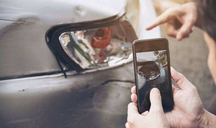 사고난 자동차를 사진찍는 남자