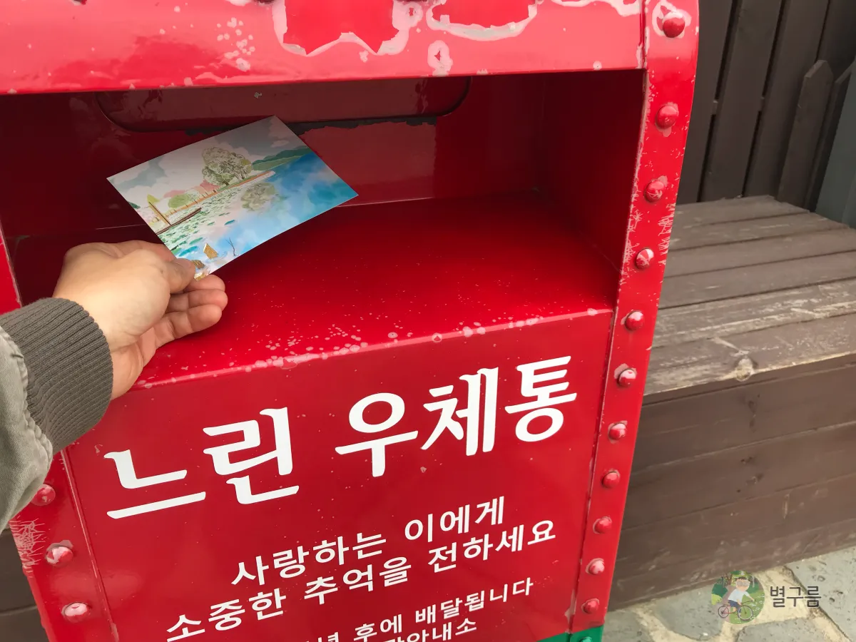 두물머리-관광안내소-엽서-투입-한손으로-넣고있다