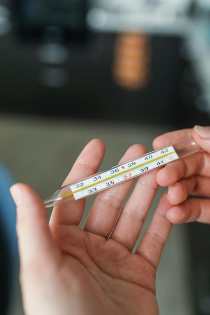 체온계로 열 측정하는 사진