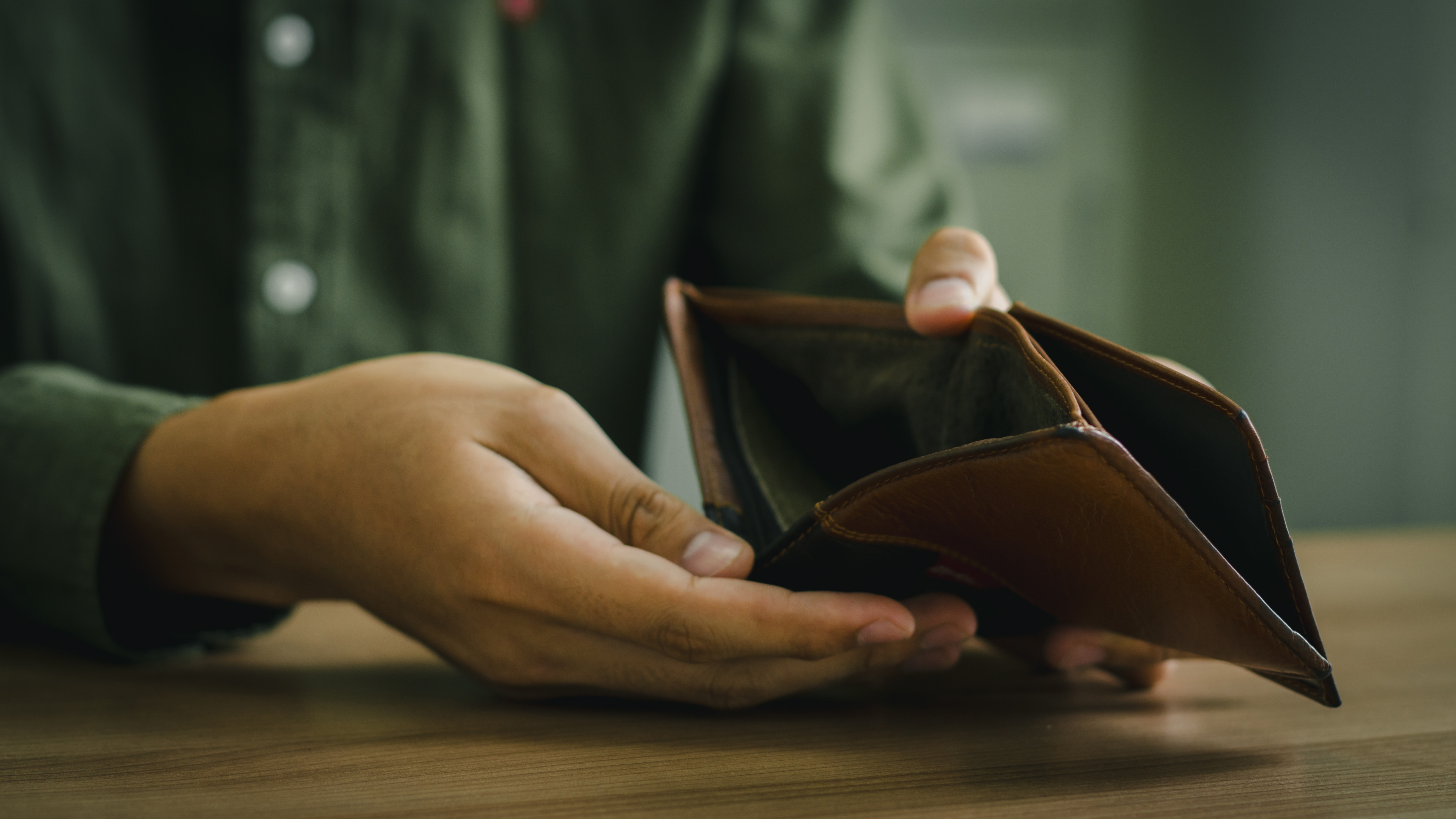 빈 지갑을 들고 있는 사람의 손, 긴급한 생계 상황을 상징하는 이미지