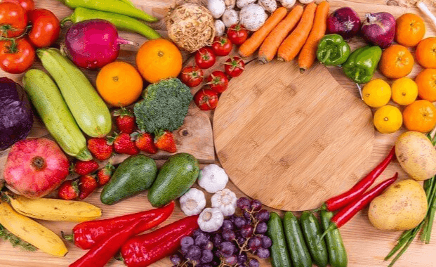 나무 탁자 위에 토마토, 호박, 고추, 아보카도, 브로콜리, 오렌지, 감자, 딸기 등 야채와 과일이 골고루 전시된 장면이다.