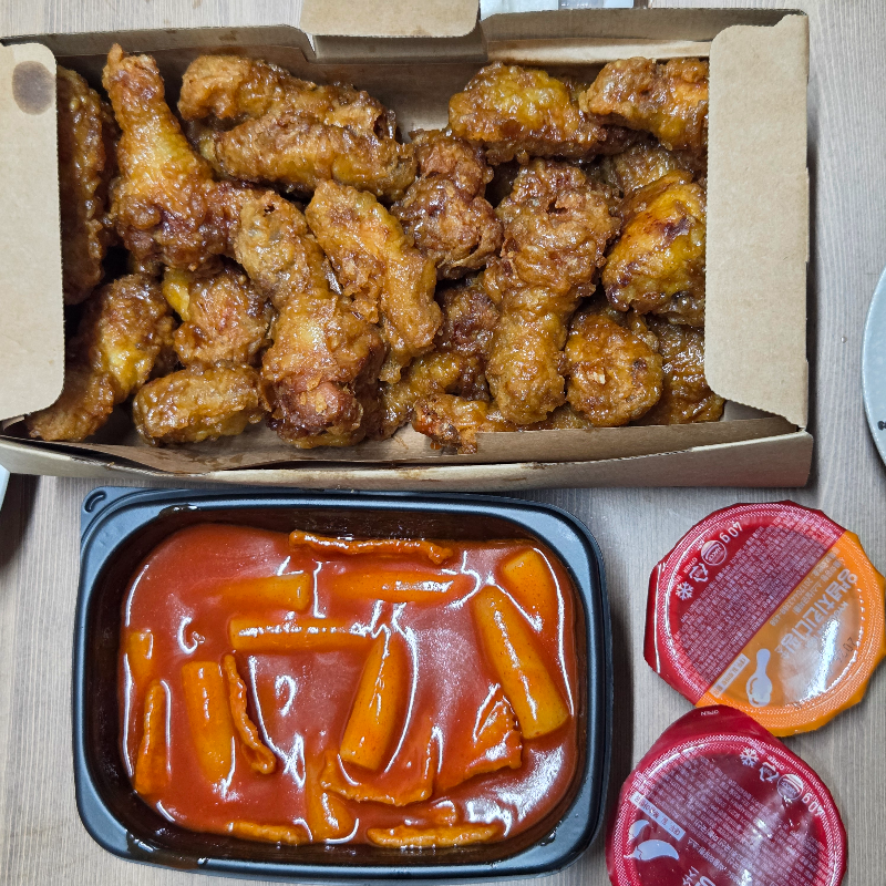 교촌 허니콤보 치킨과 빨간 국물 떡볶이 세트, 함께 먹는 테이블 위 상차림