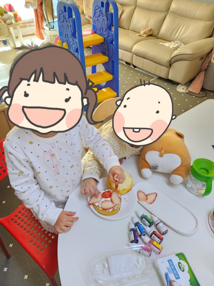 생크림 위에 딸기를 얹는 아이들