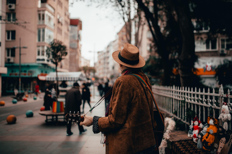 한 남자가 거리에서 기타를 들고 노래하는 모습