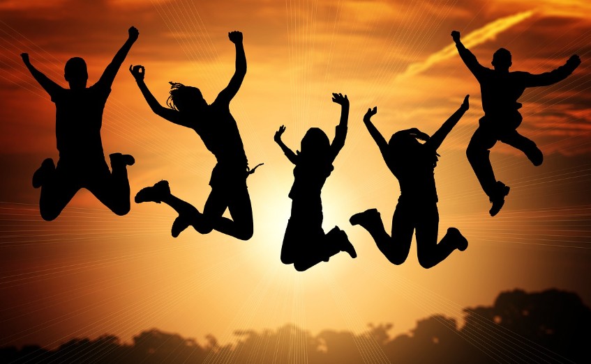 people jumping high behind sunset