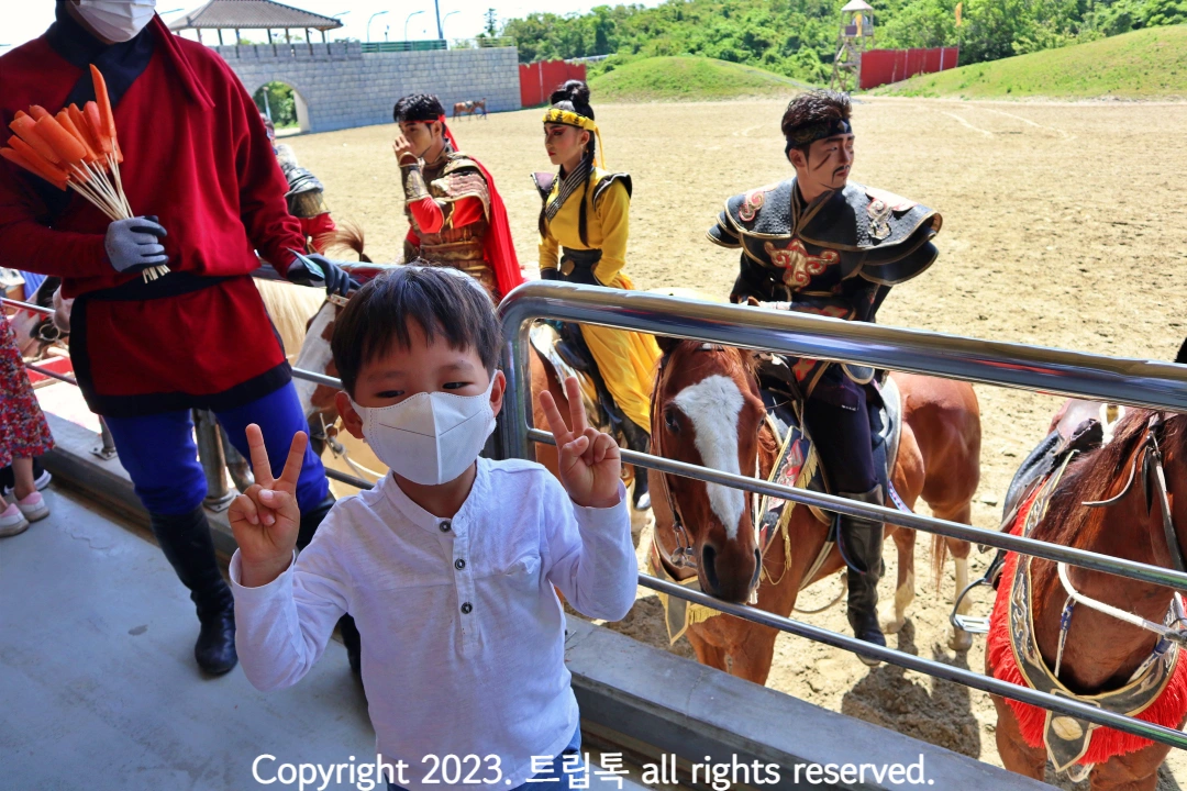 아이가 말과 몽골공연배우와 사진을 찍는다