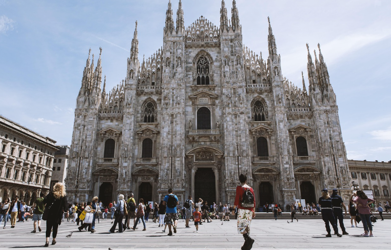 파란 하늘 아래 밀라노의 대성당이 위치해 있고 그 앞에는 많은 사람들이 대성당을 쳐다보고 있다.(밀라노)