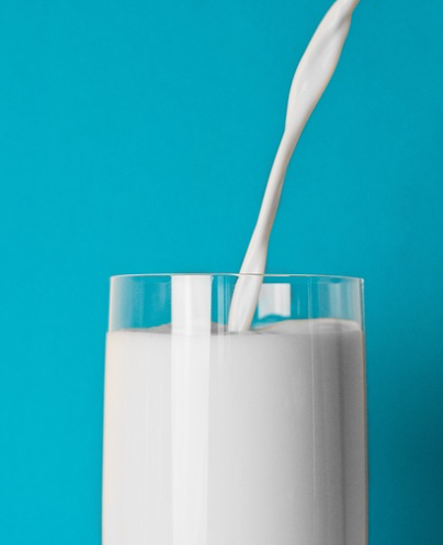 유리잔에 우유를 따르고 있다