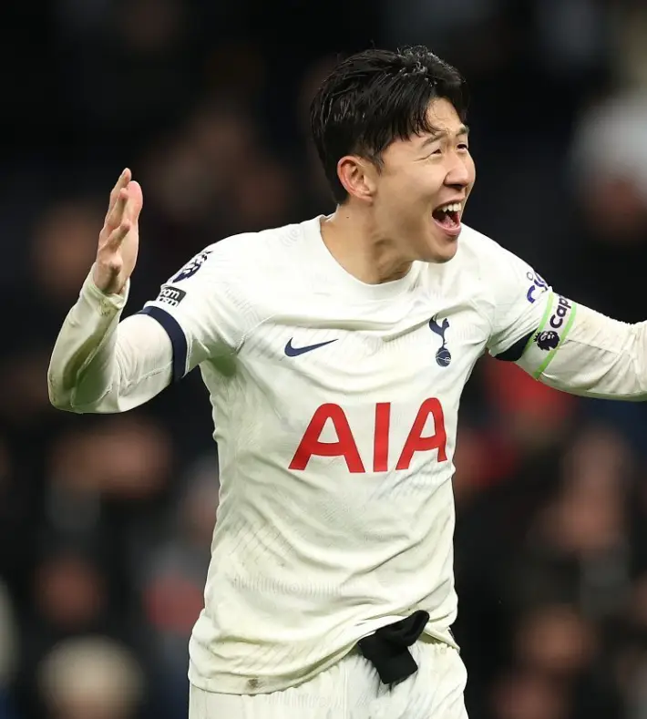 손흥민 연봉- 흰 토트넘 유니폼을 입고 관중을 향해 두팔벌려 소리치며 웃는 손흥민