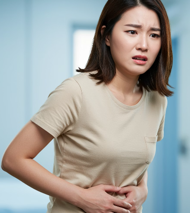배가 아파 양손으로 배를 잡고 힘들어하는 여성