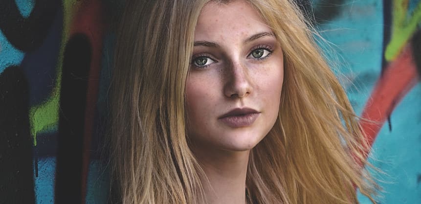 얼굴에 기미가 잇는 여성이 정면을 바라보다