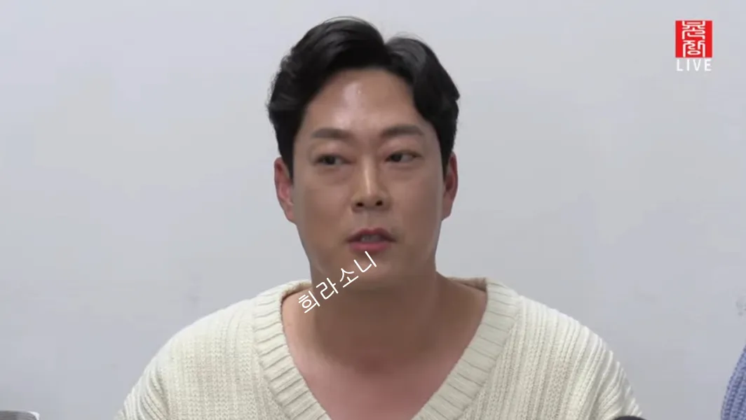 흰 색 브이넥 니트를 입은 영철.