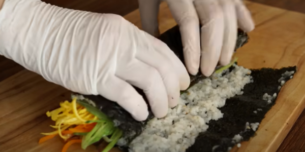 주의하며 김밥을 말고 있습니다